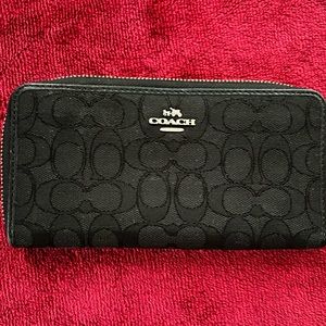Black canvas Coach wallet with silver zipper.